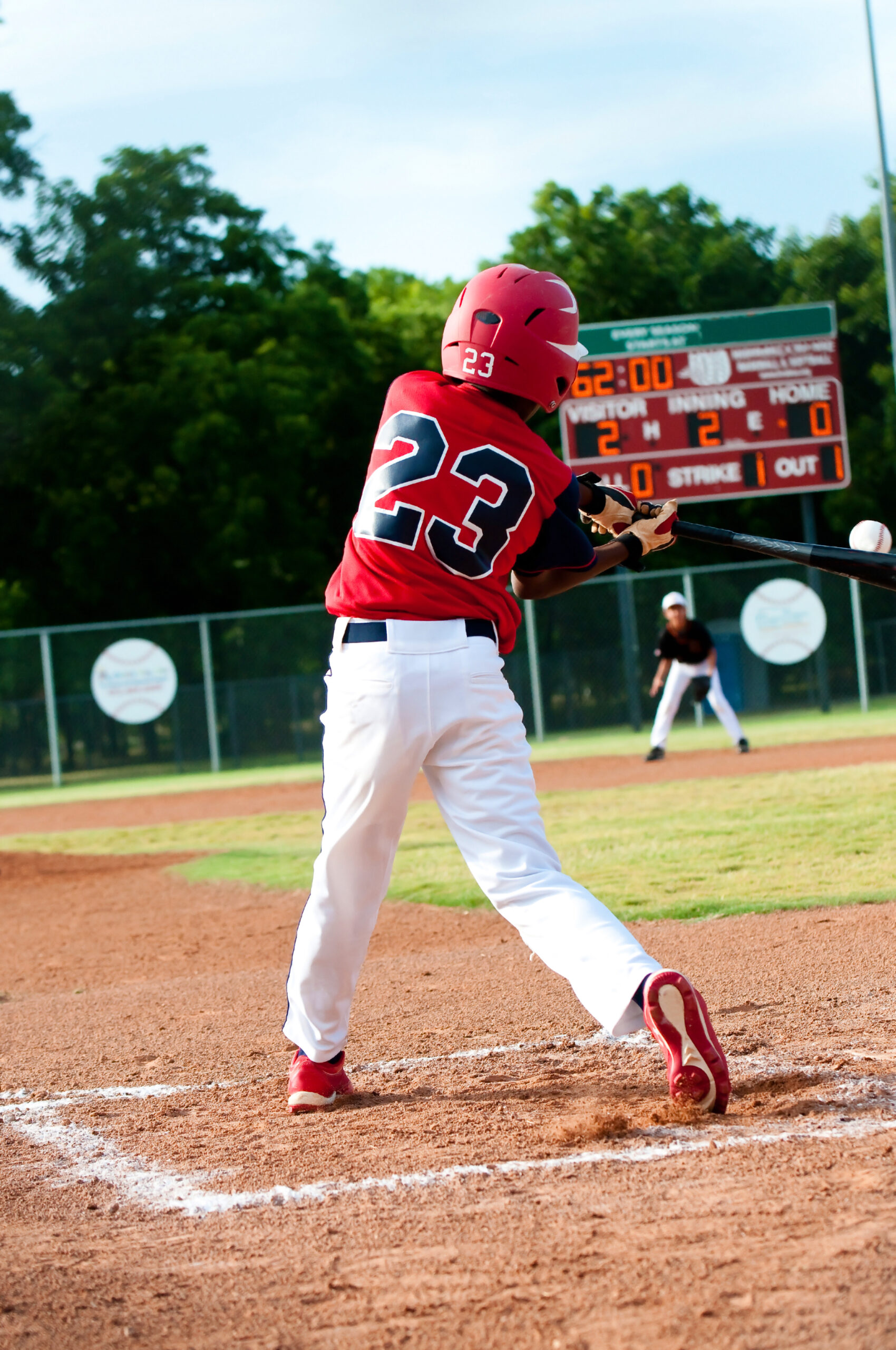 boy swinging at a pitch on a baseball field